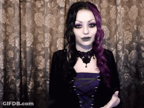 Woman With Purple And Black Hair In Front Of Curtain GIF
