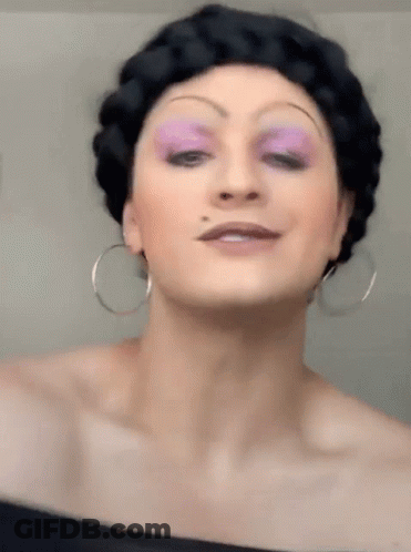 Woman With Purple Eye Shadow And Hoop Earrings GIF