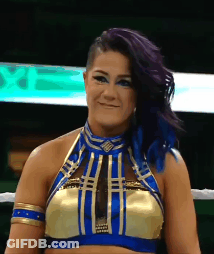 Woman With Purple Hair And Blue Eyes In Gold And Blue Top GIF