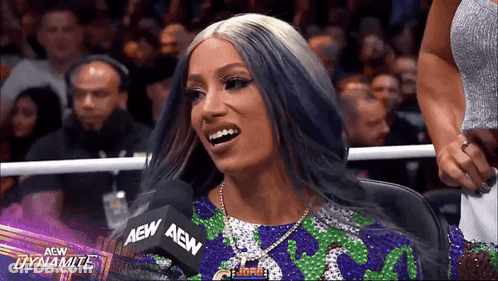 Woman With Purple Hair Sitting At Microphone GIF