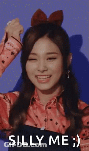 Woman With Red Bow Smiling Says Silly Me GIF
