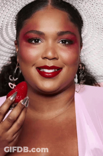 Woman With Red Eyeshadow And Red Lipstick Holding Strawberry GIF