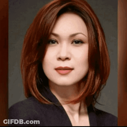 Woman With Red Hair And Black Jacket Looking At Camera GIF