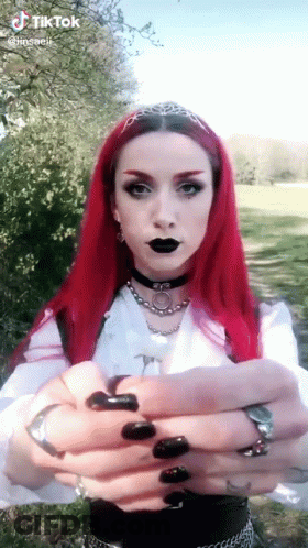 Woman With Red Hair And Black Nails Wearing Choker And White Shirt GIF