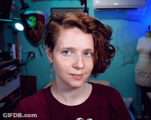 Woman With Red Hair And Blue Eyes In Burgundy Shirt GIF