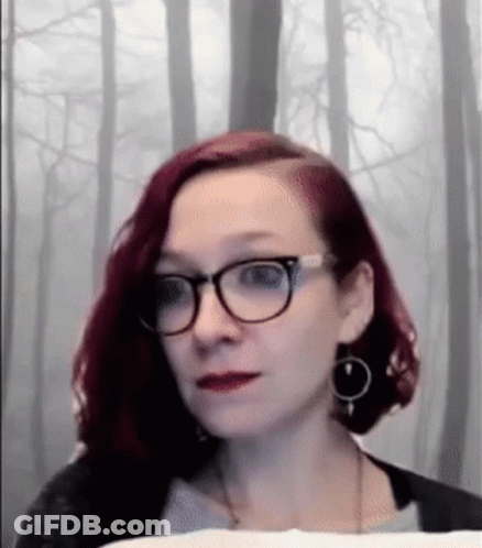 Woman With Red Hair And Glasses Looking At Camera GIF