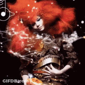 Woman With Red Hair And Gold Belt Surrounded By Smoke GIF