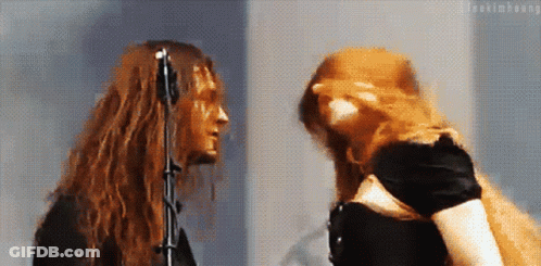 Woman With Red Hair And Man With Long Hair At Microphone GIF