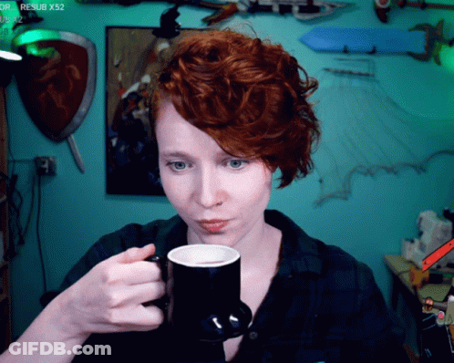 Woman With Red Hair Drinking From Black Mug GIF
