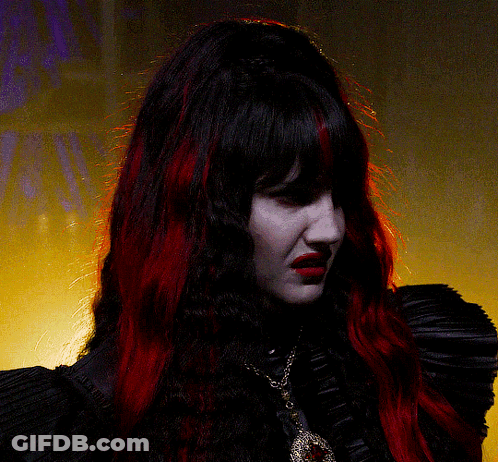 Woman With Red Hair In Black Top And Necklace GIF