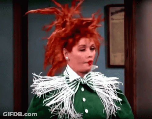Woman With Red Hair In Green Jacket And White Feather Collar GIF