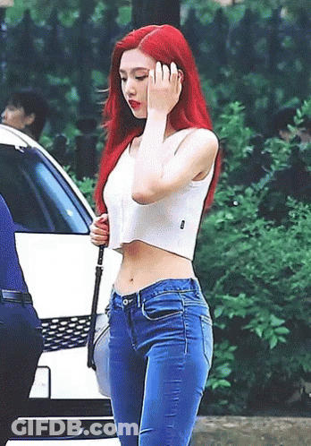 Woman With Red Hair In White Crop Top And Blue Jeans GIF