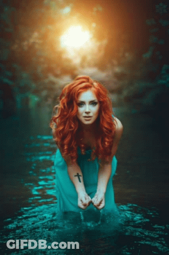 Woman With Red Hair Kneeling In Water GIF