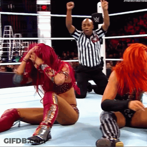 Woman With Red Hair Kneeling In Wrestling Ring With Referee GIF