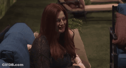 Woman With Red Hair Laughing On Blue Couch GIF