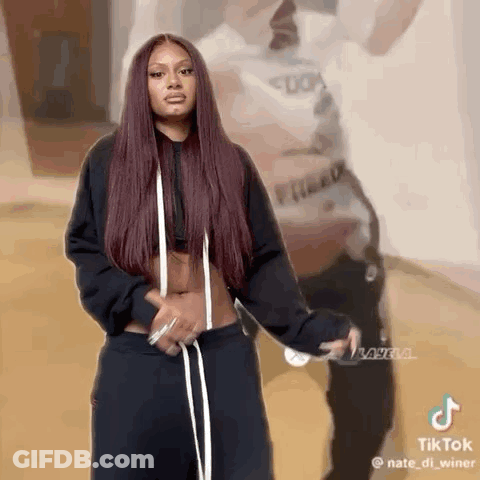 Woman With Red Hair Next To Man In White And Black GIF