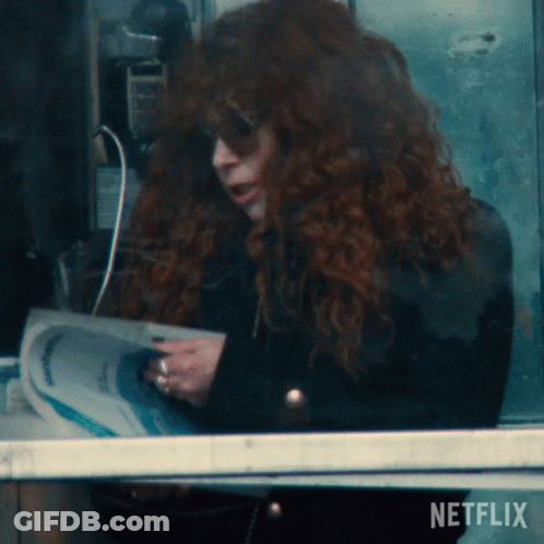Woman With Red Hair Reading Newspaper GIF