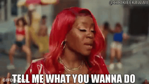 Woman With Red Hair Saying Tell Me What You Wanna Do In Front Of Group GIF