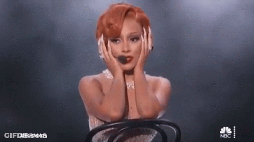 Woman With Red Hair Sitting In Chair On Stage GIF