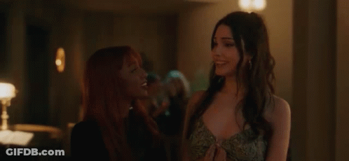 Woman With Red Hair Standing Next To Another Woman GIF