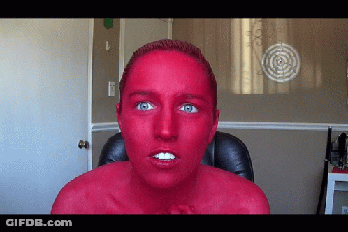 Woman With Red Paint Face Sitting Before Target GIF