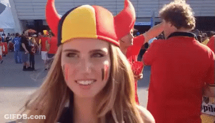 Woman With Red, Yellow, And Black Horned Hat GIF