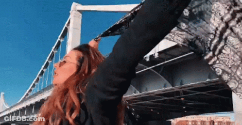 Woman With Scarf Around Head At Bridge GIF
