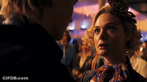 Woman With Scarf Looking At Man In Crowd GIF