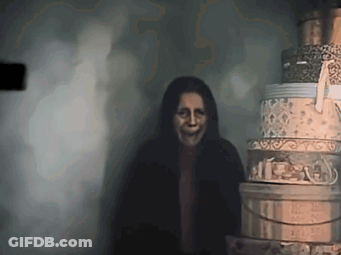 Woman With Scary Face Next To Stack Of Boxes GIF