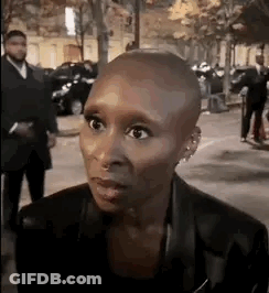 Woman With Shaved Head In Crowded Street GIF