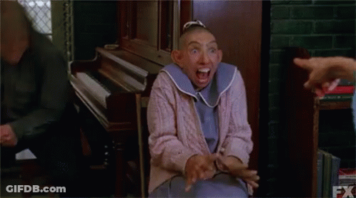 Woman With Shaved Head Making Funny Face At Piano GIF