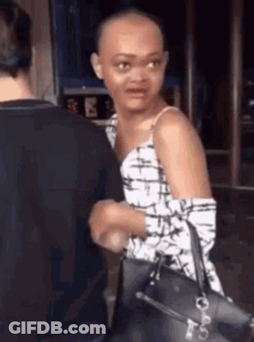 Woman With Shaved Head Standing Next To Man Holding Purse GIF