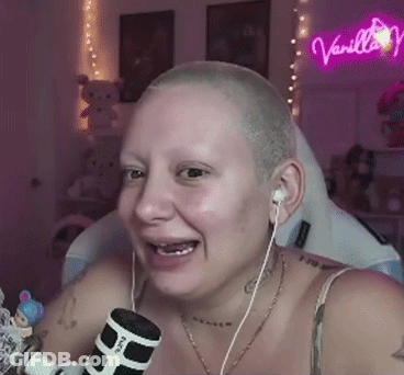 Woman With Shaved Head Wearing Earbuds Holding Microphone GIF