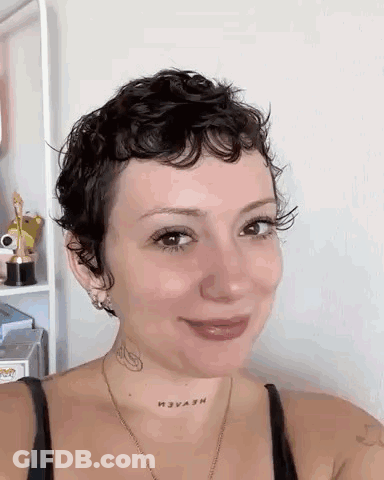 Woman With Short Curly Hair And Neck Tattoo Smiling GIF