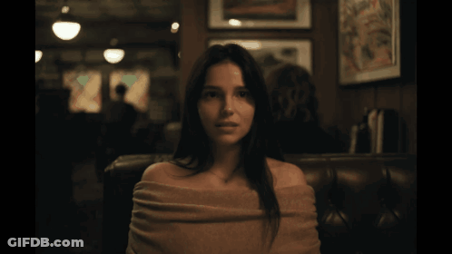 Woman With Sweater On Shoulders In Dark Room GIF