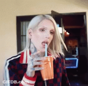 Woman With Tattoo Drinking From Cup GIF