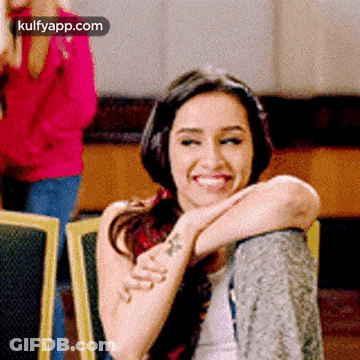 Woman With Tattoo On Arm Sitting In Chair GIF