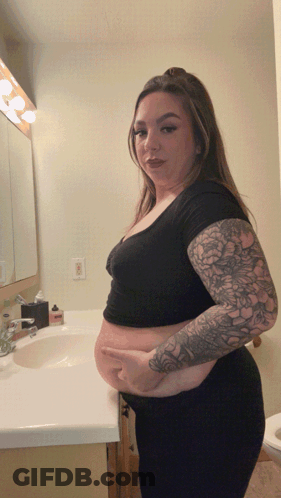 Woman With Tattoos At Bathroom Sink GIF
