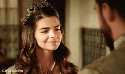 Woman With Tiara Looks At Bearded Man GIF