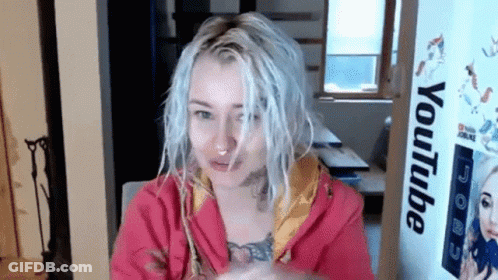 Woman With White Hair Sitting In Front Of YouTube Sign GIF