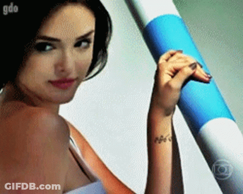 Woman With Wrist Tattoo Holding Blue And White Tube GIF