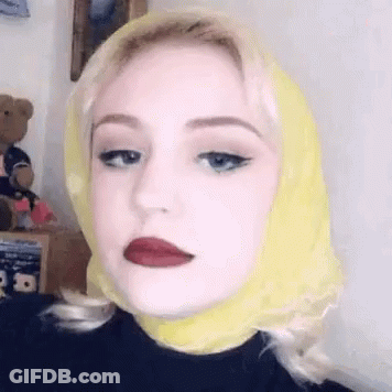 Woman With Yellow Scarf And Red Lipstick Making Funny Face GIF