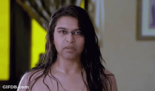 Woman Without Shirt Looking At Camera Yellow Wall GIF