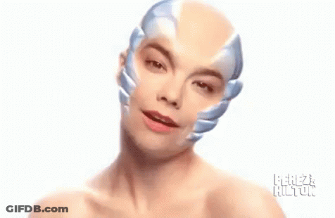 Woman Without Shirt Wearing Robot Mask GIF