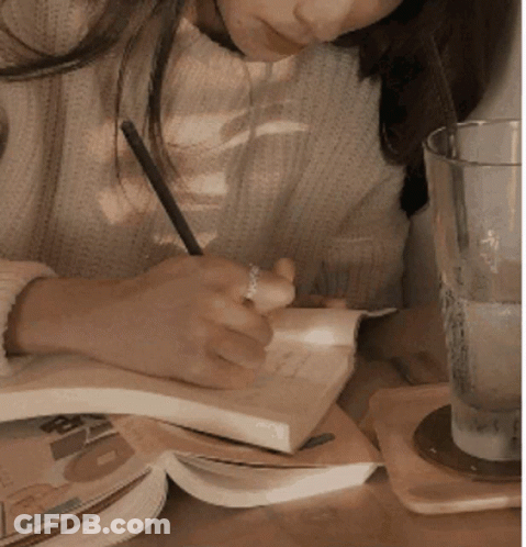 Woman Writing In Notebook At Table GIF