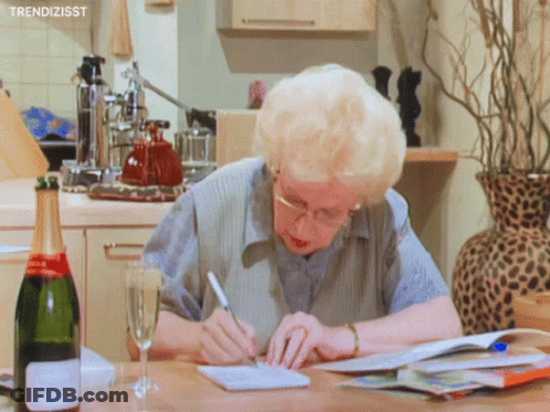Woman Writing Next To Champagne Glass GIF
