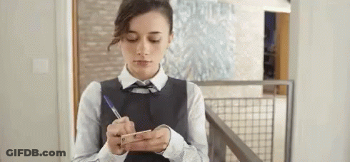 Woman Writing On Paper While Looking At Phone GIF