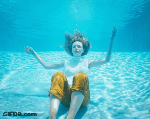 Woman Yellow Pants Underwater Arms Outstretched GIF