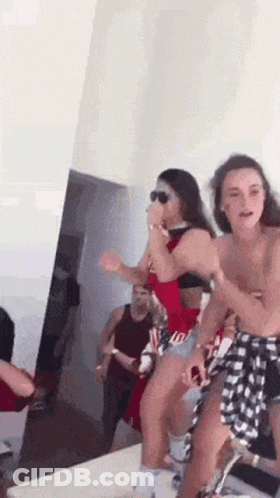 Women Dancing In A Room With Man In Background GIF