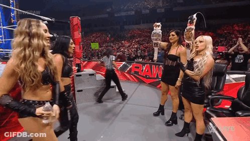 Women Holding Championship Belt On Stage GIF